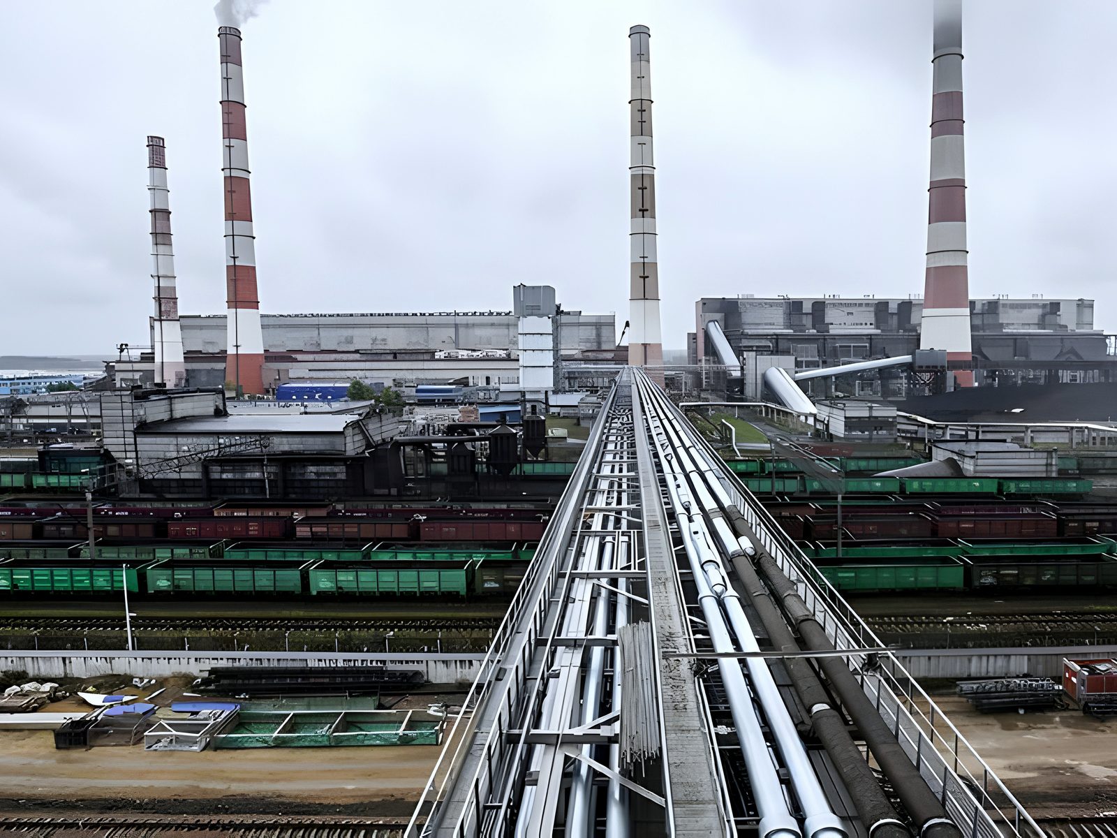 Power station panorama: striped chimneys, pipeline runs, coal wagons