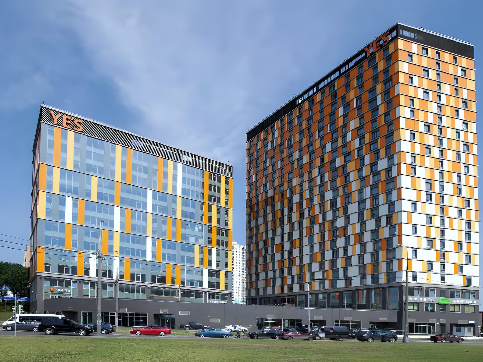 Street view of the complex with orange-panelled facades and roof signs