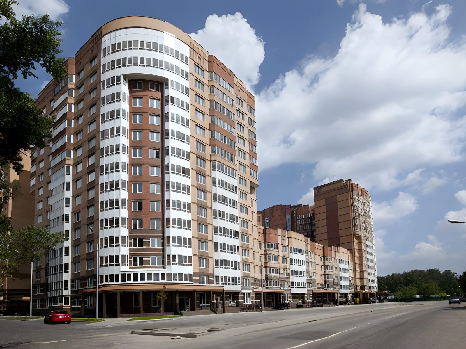 Rounded-corner high-rise apartment tower on a sunny street