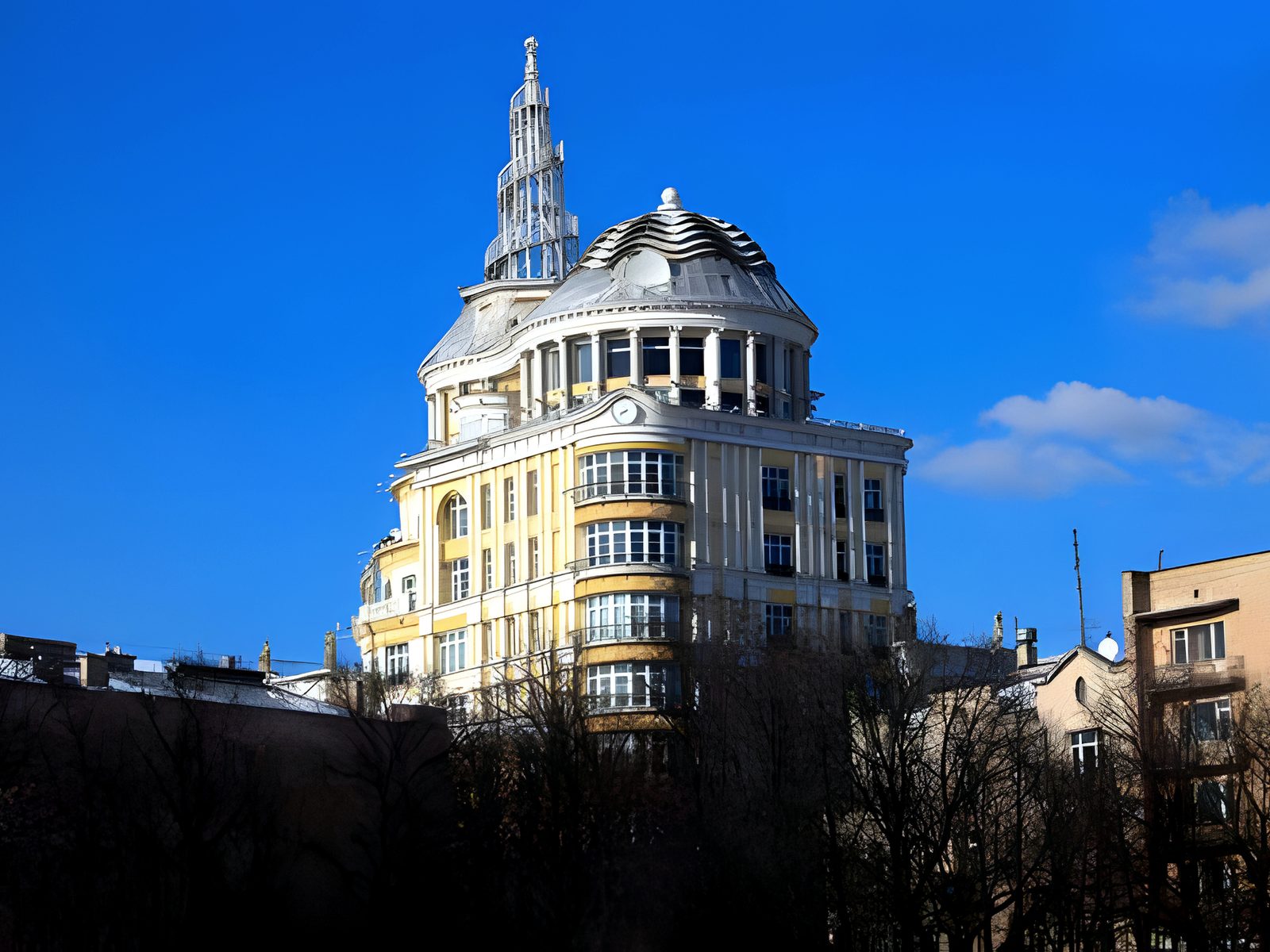 Domed classical apartment tower above bare winter trees