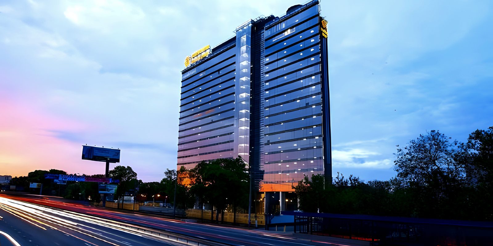 Dusk view of office tower with highway light trails