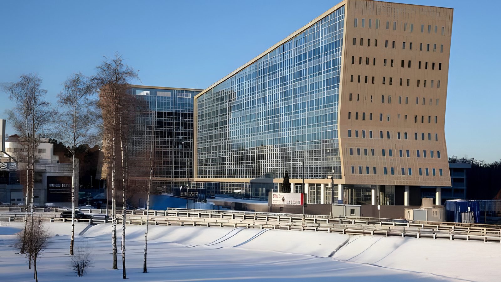 Winter exterior of sloping glass and gold-clad office blocks