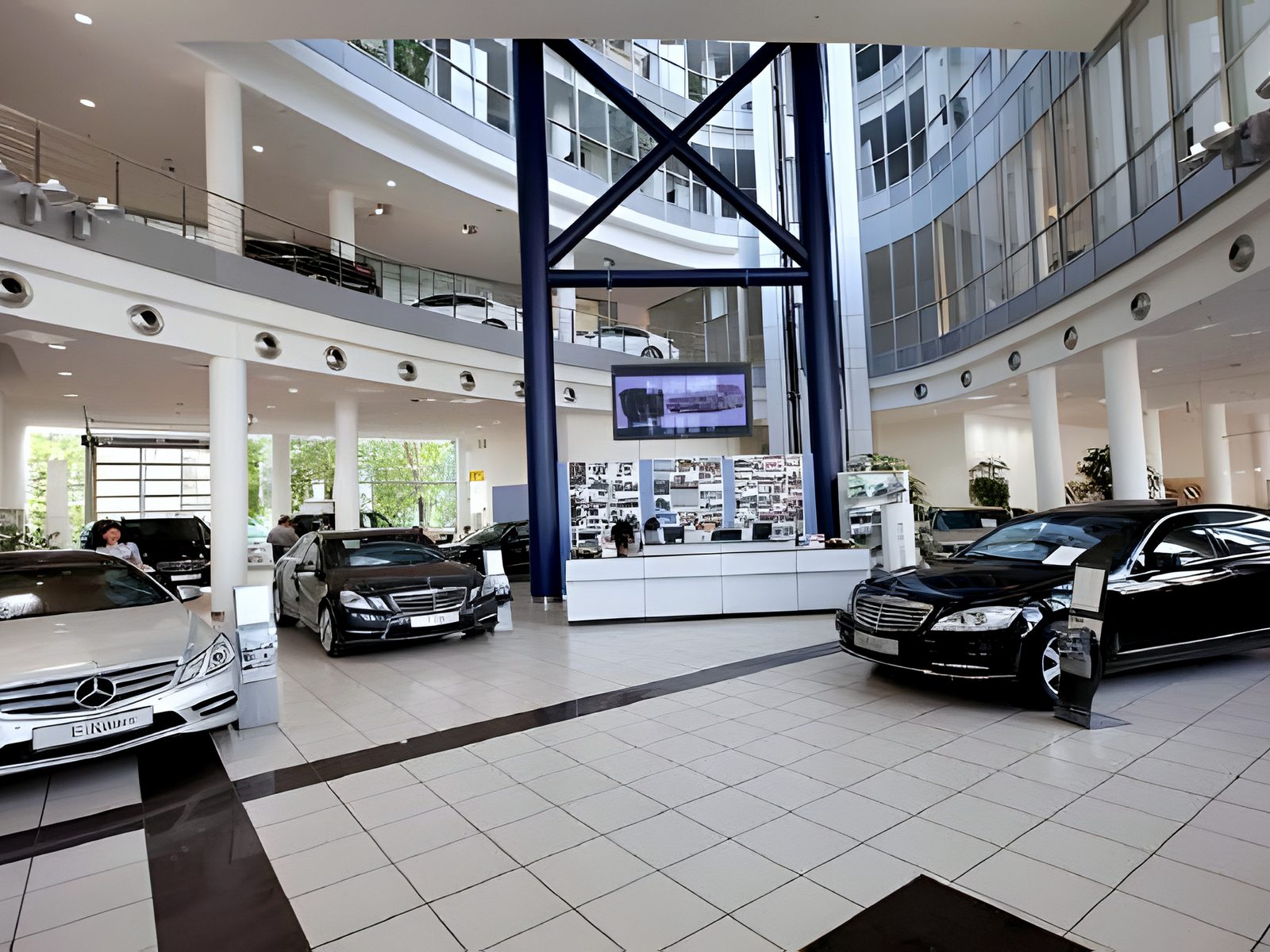 Car showroom inside the glazed atrium, saloons on tiled floor