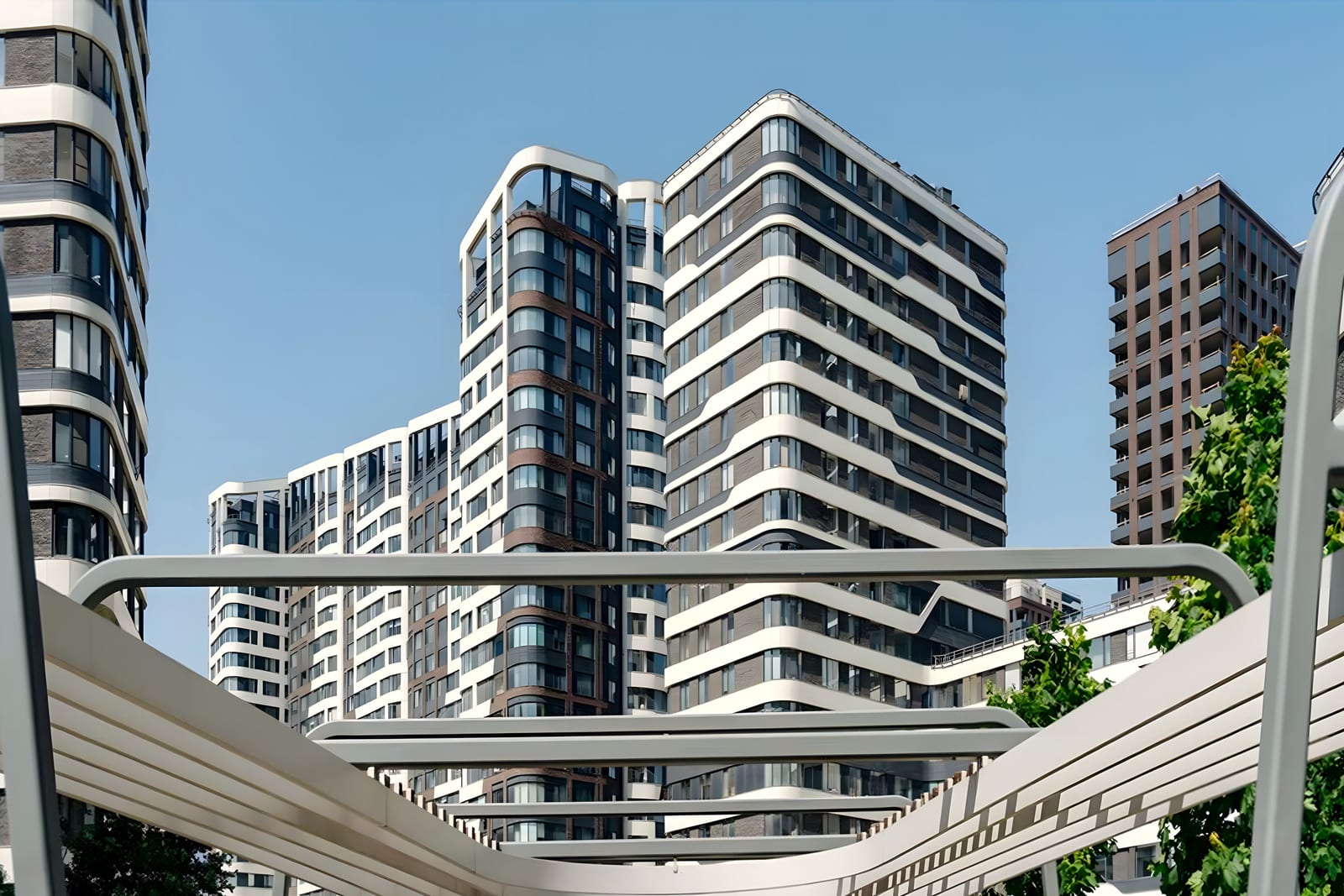 Curved-balcony residential towers behind a white steel canopy