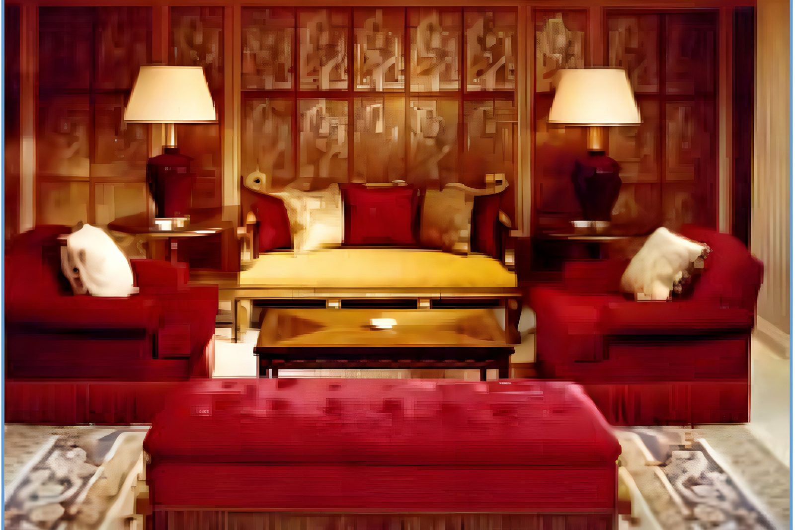 Gilt-panelled salon with red sofas and a gold daybed