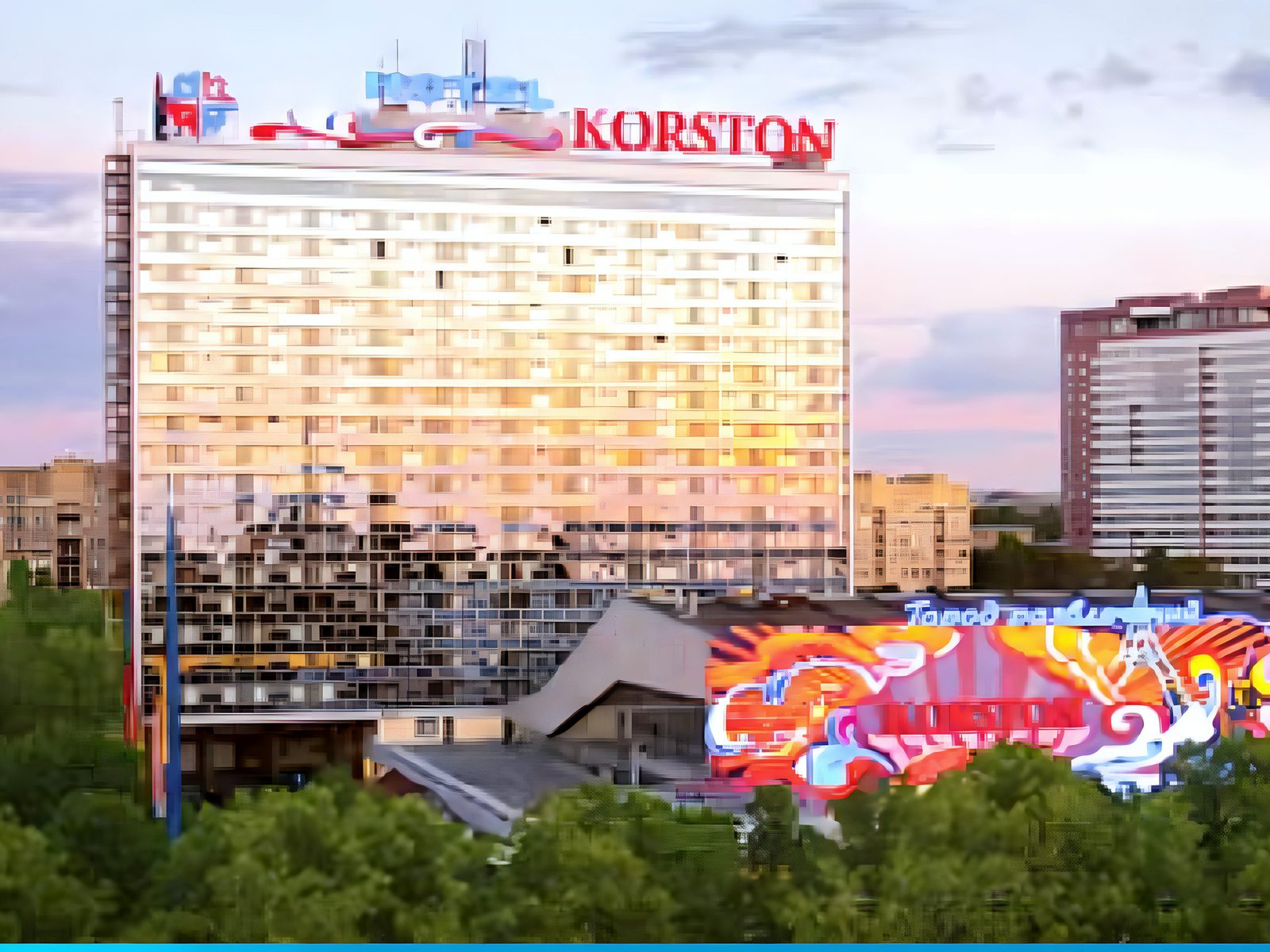 The Korston hotel slab at dusk with red KORSTON roof letters and a painted mural on the low block in front