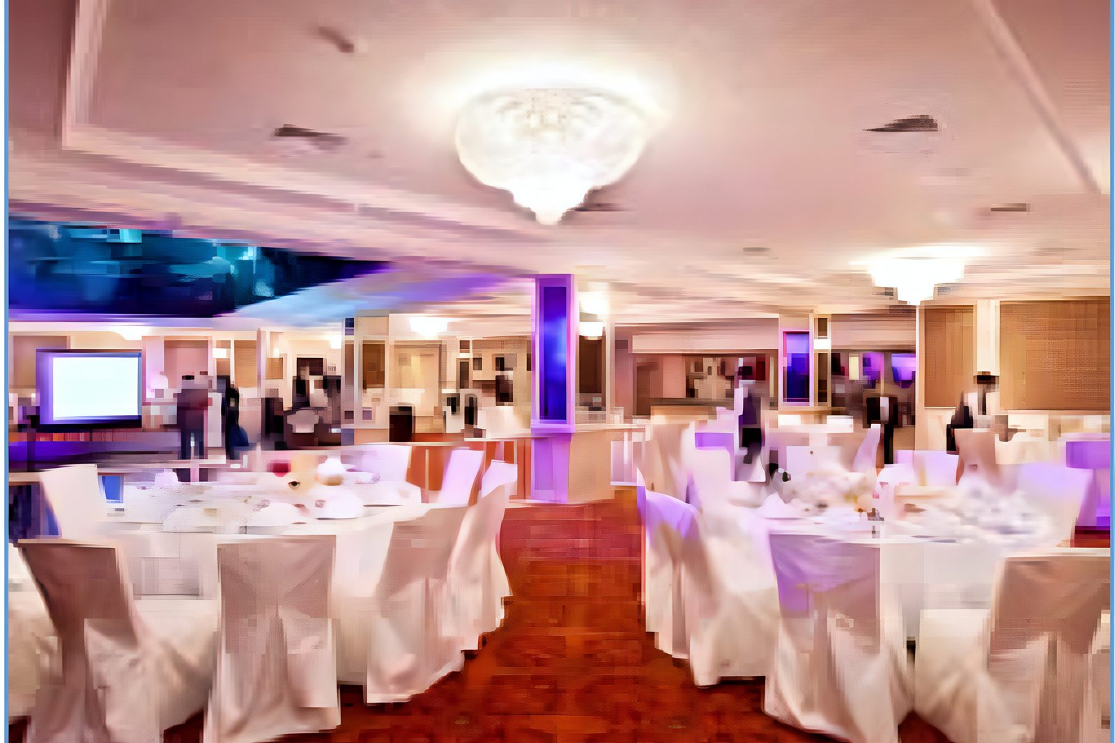 Banquet hall with round tables and guests under stage lighting